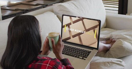 Poster - Biracial woman using laptop at home online shopping on cyber monday sale day, slow motion