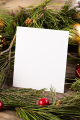 Poster - Vertical image of christmas decorations, white card and copy space on wooden background