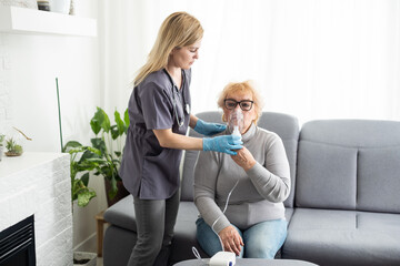 Wall Mural - Elderly woman using inhaler for asthma and respiratory diseases at home