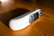 Digital ear thermometer on a wooden desk - shallow DOF
