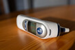 Digital ear thermometer on a wooden desk - shallow DOF