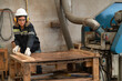 © chachamp - Caucasian technician craft woman working with cut timber machine at wood factory