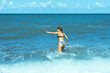 © AleksFil - Teenage girl running towards sea splashing waves