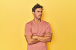 © Asier - Young Latino man posing on yellow background suspicious, uncertain, examining you.