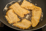 Fototapeta  - Ryba smażona na patelni, panierowane kawałki ryby na rozgrzanym tłuszczu 
