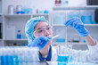 © Supapich - Professional woman specialist doctor laboratory white uniform use thermometer temperature on blue liquid in healthcare and medicine experiment equipment with glove care, young adult female scientist