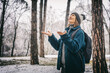 © olezzo - Adult mature woman breathes fresh air and enjoys the snowfall in the winter forest