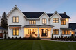Beautiful modern farmhouse style luxury home exterior at twilight 