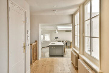 a kitchen and dining area in a house with wood floors, white walls, and large windows looking out onto the street