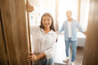 © Prostock-studio - Indian couple warmly welcoming guests near the open door