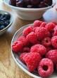 fresh raspberries and blueberries on a kitchen countertop