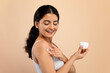 © Prostock-studio - Skin Nourishing Concept. Beautiful Indian Woman Applying Moisturizing Body Cream