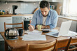 © Geber86 - Stressed young man going over bills and payments in the kitchen