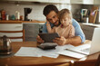 © Geber86 - Young father using the tablet with his daughter in the kitchen