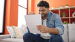 © Krakenimages.com - African american man reading document sitting on sofa with winner expression at home