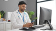 © Krakenimages.com - African american man doctor using computer and smartphone at clinic