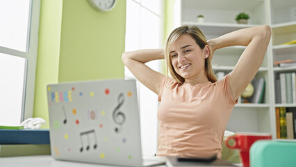 Sticker - Young blonde woman student using computer relaxing with hands on head at library university