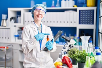 Canvas Print - Beautiful woman working at scientist laboratory with food smiling happy pointing with hand and finger