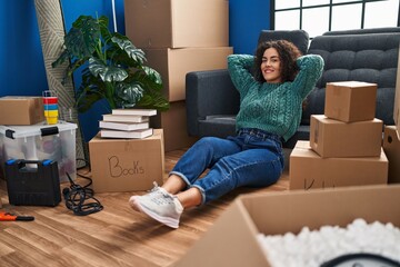 Sticker - Young beautiful hispanic woman sitting on floor relaxed with hands on head at new home