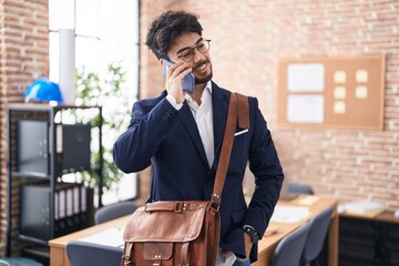 Sticker - Young hispanic man business worker talking on smartphone at office