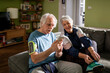 © Marko Geber - Senior couple using a smartphone at home before going out to exercise together