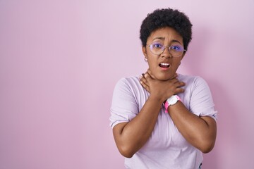 Canvas Print - Young african american woman standing over pink background shouting and suffocate because painful strangle. health problem. asphyxiate and suicide concept.