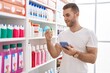 © Krakenimages.com - Young caucasian man customer using smartphone holding deodorant at pharmacy