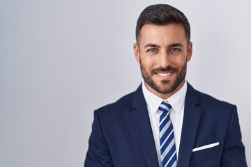 Canvas Print - Handsome hispanic man wearing suit and tie with hands together and crossed fingers smiling relaxed and cheerful. success and optimistic