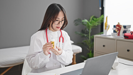 Canvas Print - Young chinese woman doctor having video call prescribe pills treatment at clinic