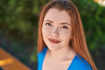 Poster - Young redhead woman smiling confident sitting on bench at park