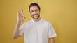 © Krakenimages.com - Young hispanic man smiling confident doing ok sign over isolated yellow background