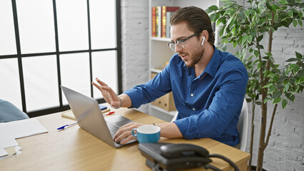 Wall Mural - Young hispanic man business worker having video call at the office