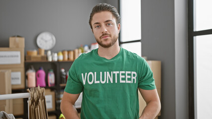 Wall Mural - Young hispanic man volunteer standing withe serious face at charity center