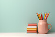 colored pencils in ceramic mug and colorful book on blue green background Knowledge and education concept