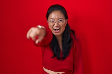 Poster - Asian young woman standing over red background pointing displeased and frustrated to the camera, angry and furious with you