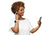 © Damir Khabirov - Young african american woman listening to music via wireless earphones, using music streaming service app on phone