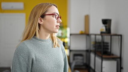 Wall Mural - Young blonde woman business worker looking to the side at office