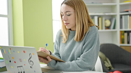 Poster - Young blonde woman student using laptop writing on notes at library university