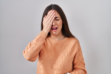 Sticker - Young brunette woman standing over white background yawning tired covering half face, eye and mouth with hand. face hurts in pain.