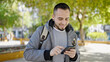 © Krakenimages.com - Hispanic man using smartphone smiling at the park
