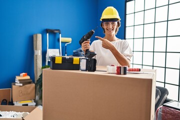 Sticker - Brunette woman holding screwdriver at new home smiling happy pointing with hand and finger