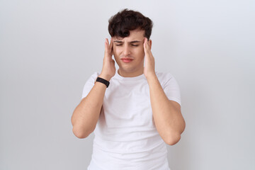 Poster - Young non binary man wearing casual white t shirt with hand on head, headache because stress. suffering migraine.