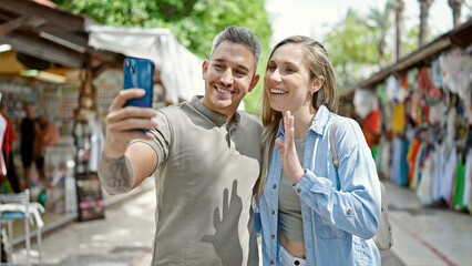 Canvas Print - Man and woman couple smiling confident having video call at street market