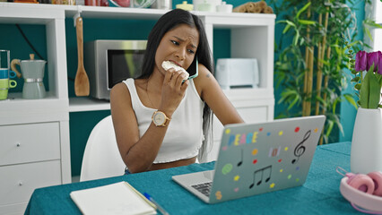 Wall Mural - African american woman talking on smartphone eating rice cake at dinning room