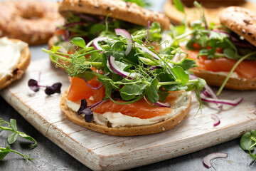 Wall Mural - Smoked salmon and soft cheese seeded bagel with pea and purple reddish shoot salad and red onion. Protein packed breakfast concept