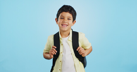 Canvas Print - School, happy or face of child in studio on blue background ready for class, learning and education. Student, smile or portrait of a young boy with bag excited for lesson, academy or kindergarten