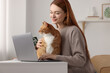 © New Africa - Woman with cat working at desk. Home office