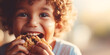 Close up portrait of a happy toddler kid eating a fresh baked cookie, blurred background