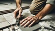 Close-up photo of a craftsman's hands, equipped with tools, as he attentively aligns and sets tiles in place.