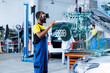 © DC Studio - African american mechanic in repair shop using AR holograms to check car performance parameters during maintenance. Certified garage employee using futuristic vr headset to examine damaged vehicle